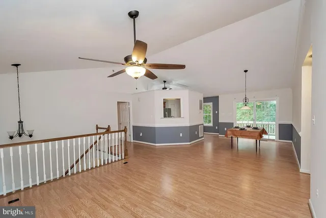 a view of a dining room and livingroom with furniture wooden floor a chandelier