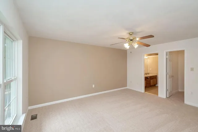 a view of an empty room with a chandelier fan