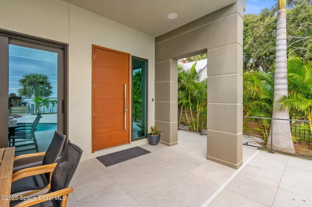 a view of a balcony with two chairs and a potted plant