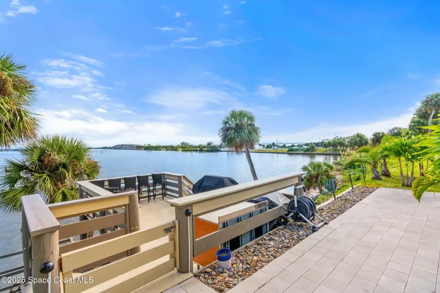 a view of a balcony with chairs and iron stairs