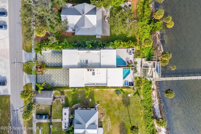 a kitchen with stainless steel appliances kitchen island granite countertop a refrigerator a stove and a dining table with wooden floor