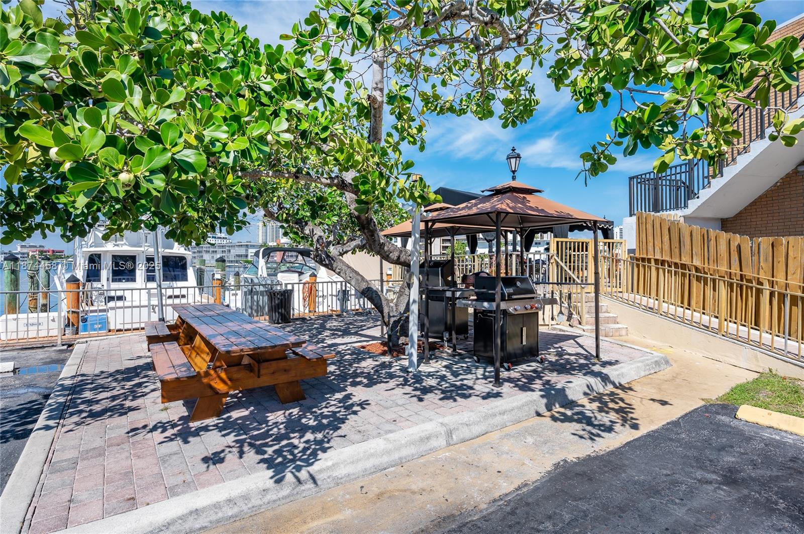 100 Golden Isles Drive, Unit 104 Hallandale Beach, FL 33009 - Photo 3 of 28 a wooden bench sitting in front of a house