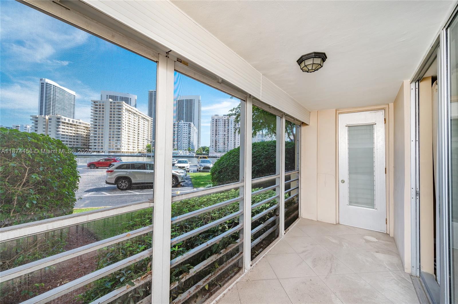 100 Golden Isles Drive, Unit 104 Hallandale Beach, FL 33009 - Photo 9 of 28 a view of a porch with wooden floor and fence in front of it