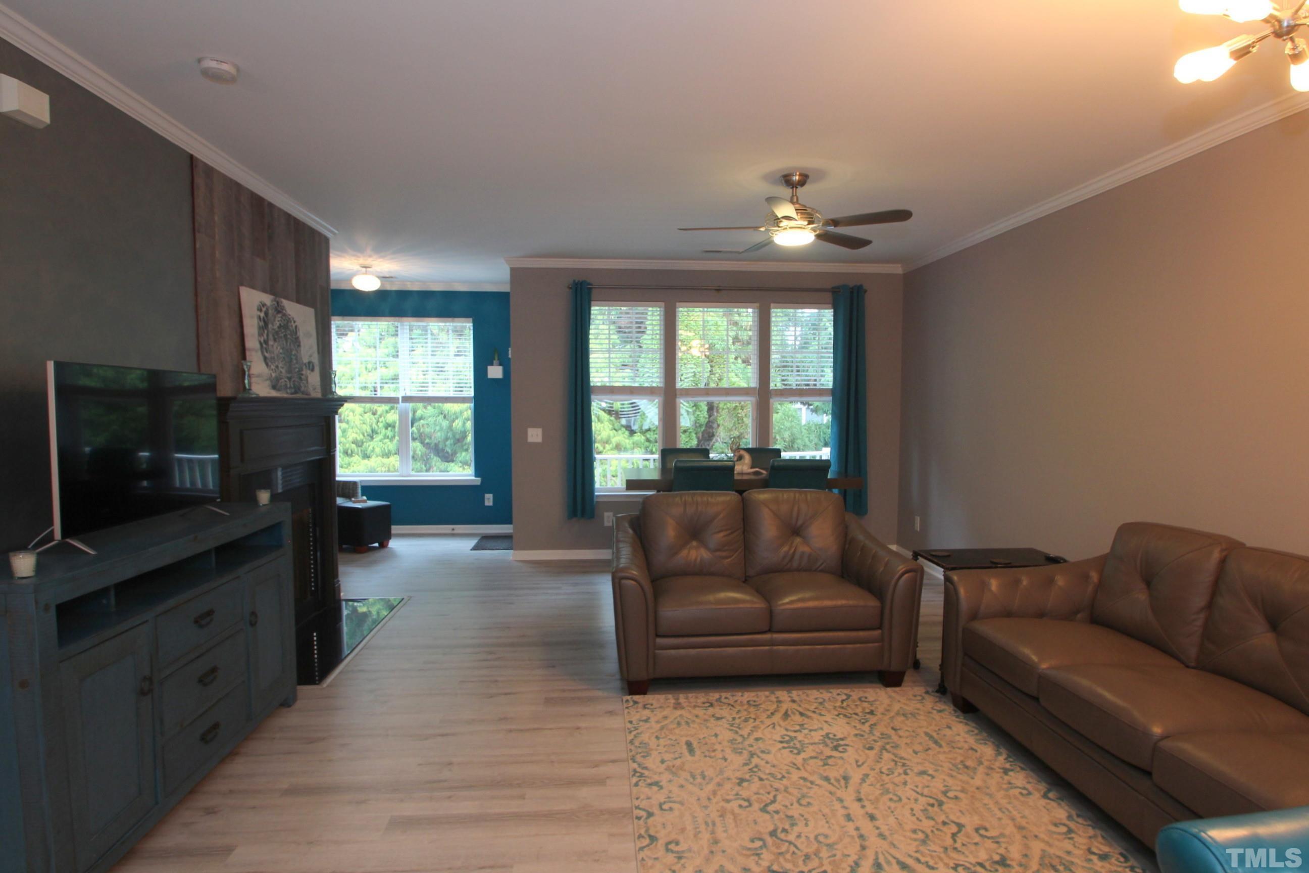 5804 Cameo Glass Way Raleigh, NC 27612 - Photo 17 of 25 a living room with furniture a flat screen tv and a floor to ceiling window