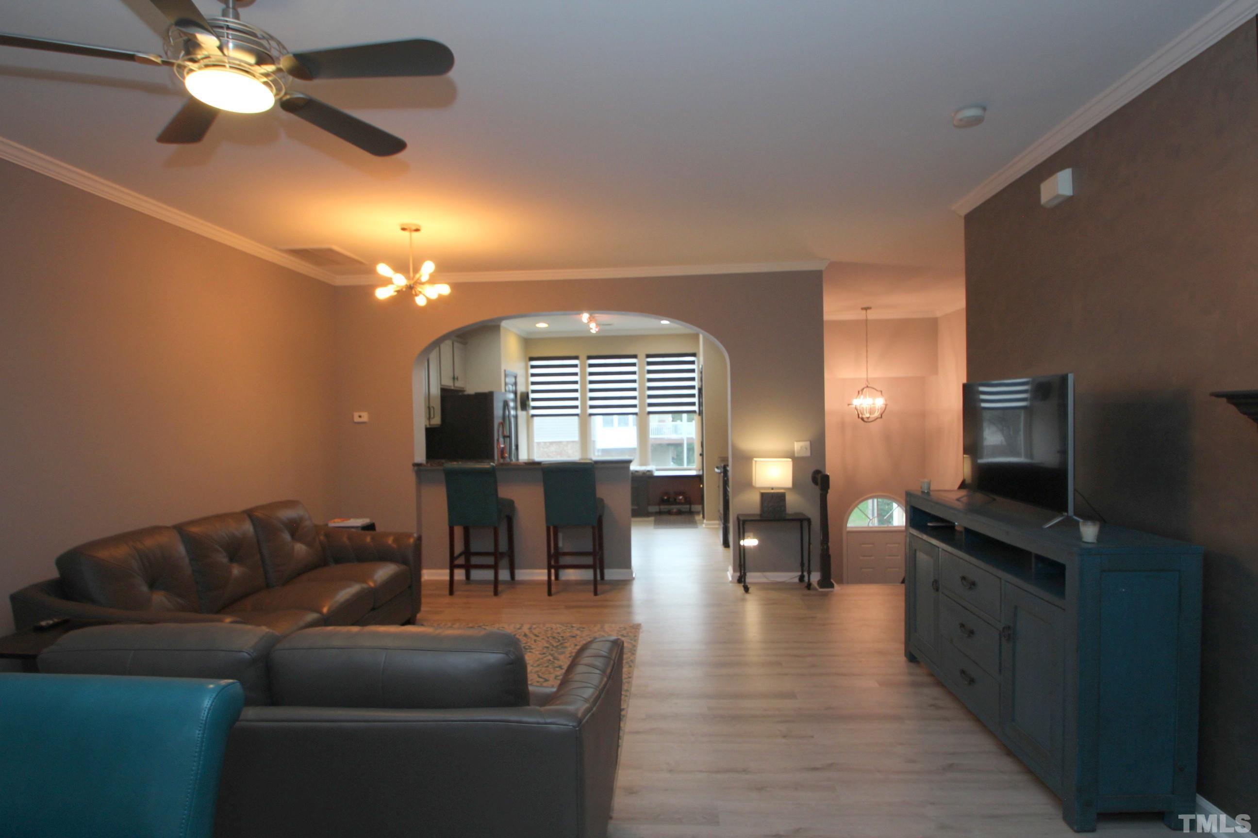 5804 Cameo Glass Way Raleigh, NC 27612 - Photo 8 of 25 a living room with furniture a dining table a lamp and a flat screen tv