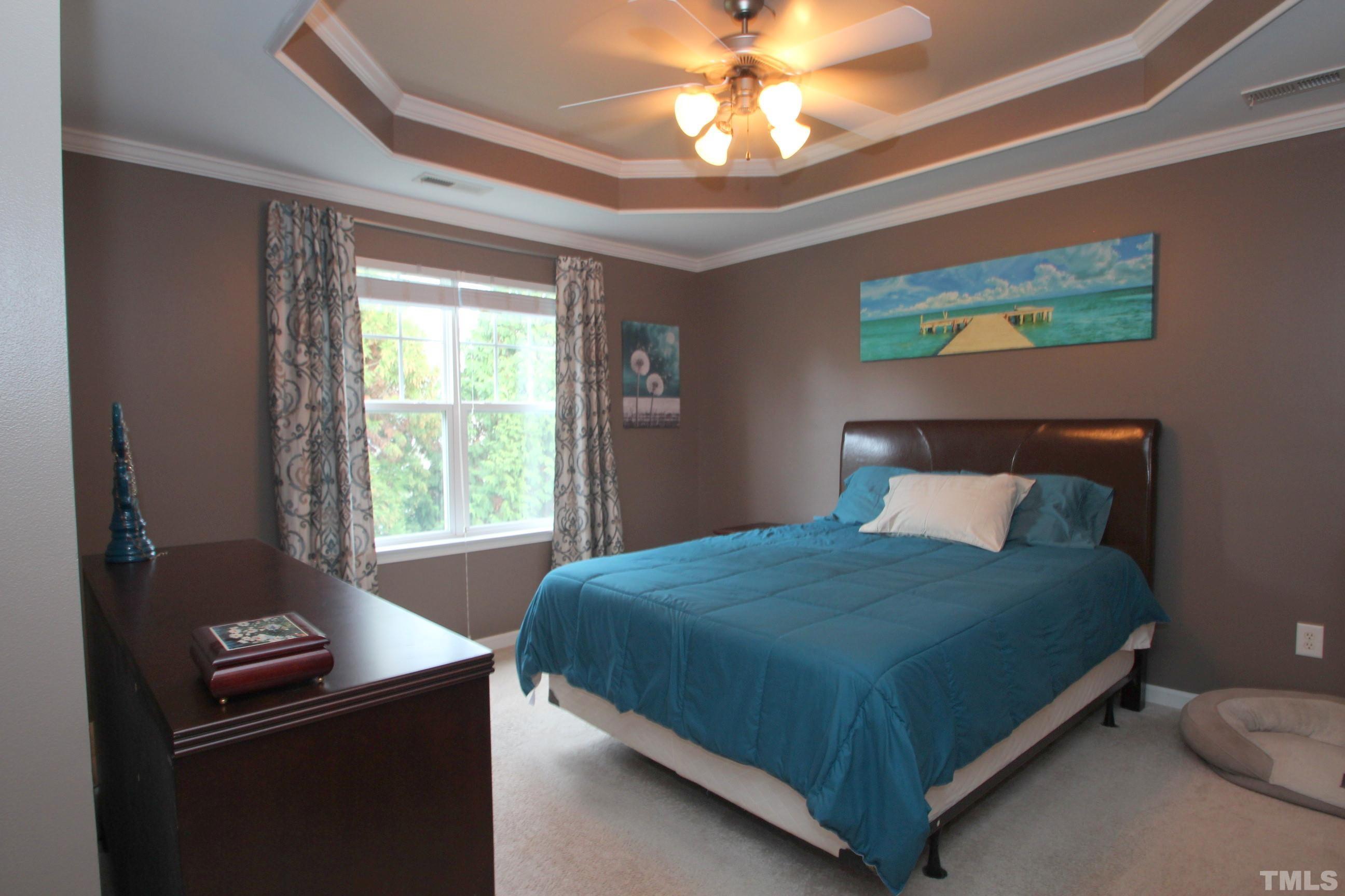 5804 Cameo Glass Way Raleigh, NC 27612 - Photo 9 of 25 a bedroom with a bed and a chandelier