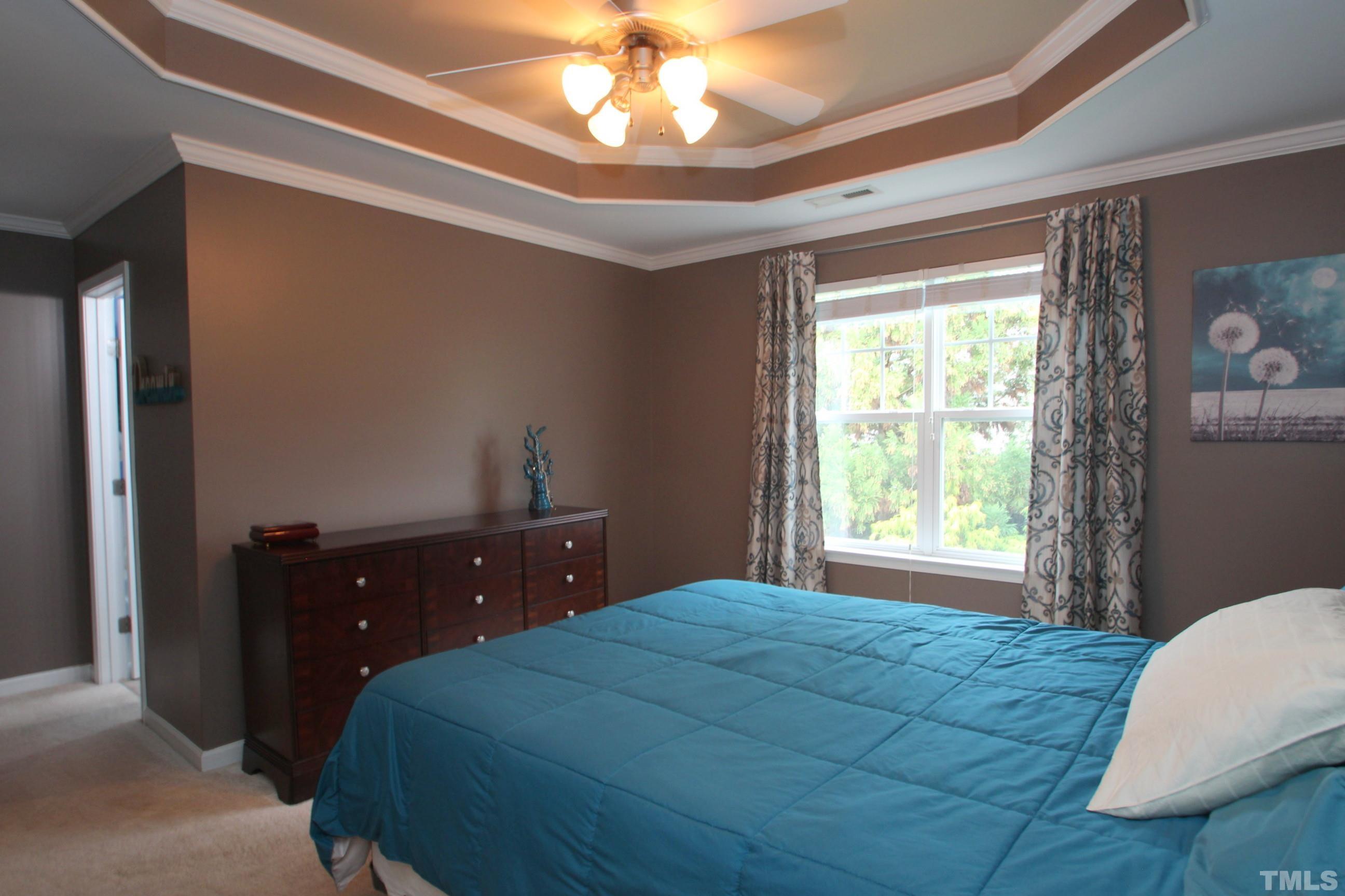 5804 Cameo Glass Way Raleigh, NC 27612 - Photo 10 of 25 a bedroom with a bed and a chandelier
