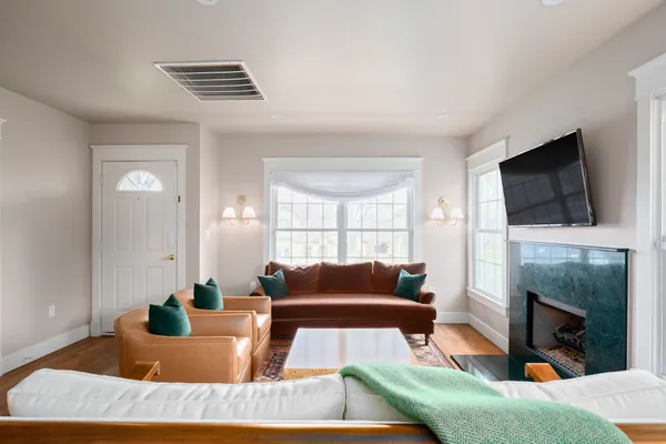 a living room with furniture a flat screen tv and a fireplace