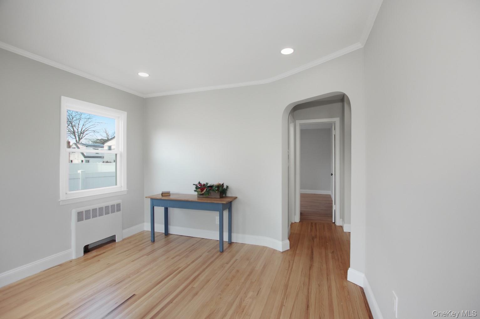 57 Remson Street Valley Stream, NY 11580 - Photo 9 of 27 Living room with refinished hardwood floors, crown molding and original arched doorways