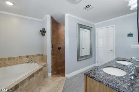 a bathroom with a granite countertop tub sink and mirror