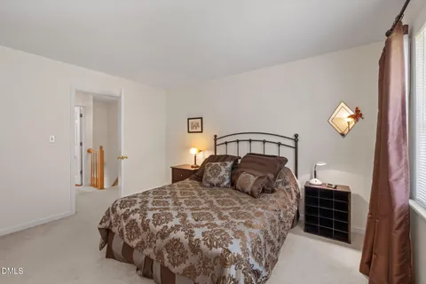 a bedroom with a bed and painting on the wall