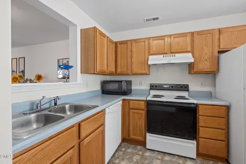 a kitchen with a sink stove and cabinets