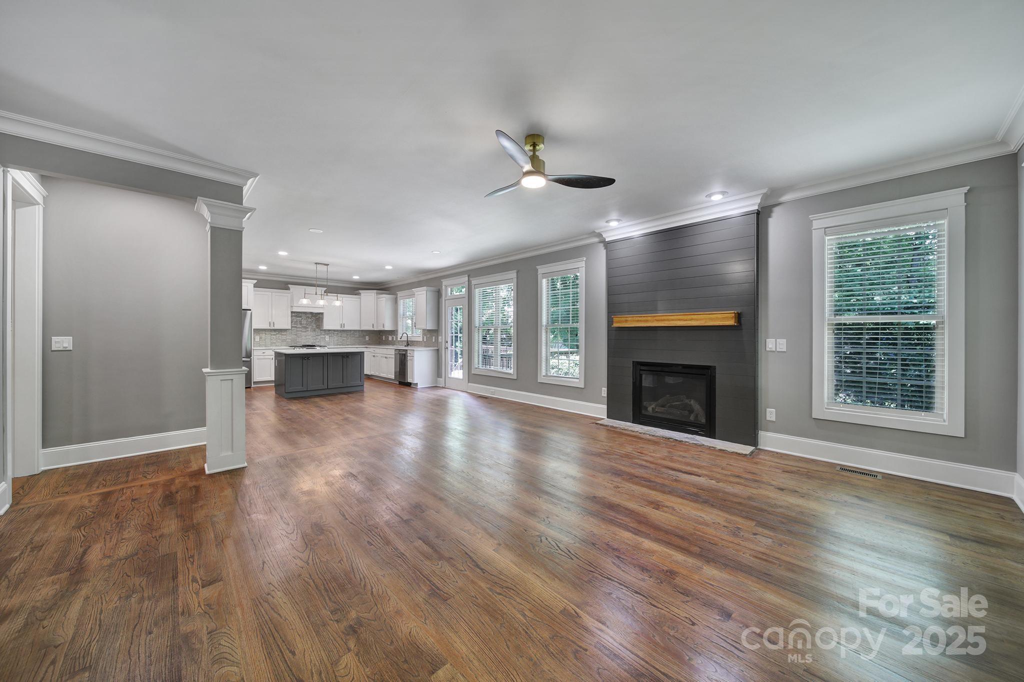 5633 Open Book Lane Charlotte, NC 28270 - Photo 11 of 48 a view of an empty room with wooden floor fireplace and a window