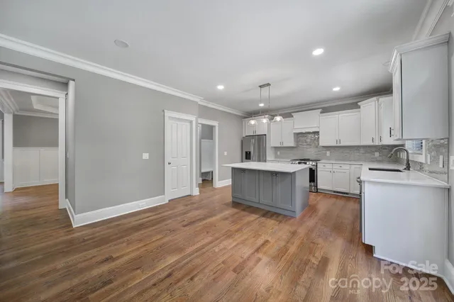 a kitchen with kitchen island granite countertop a sink appliances cabinets and counter space
