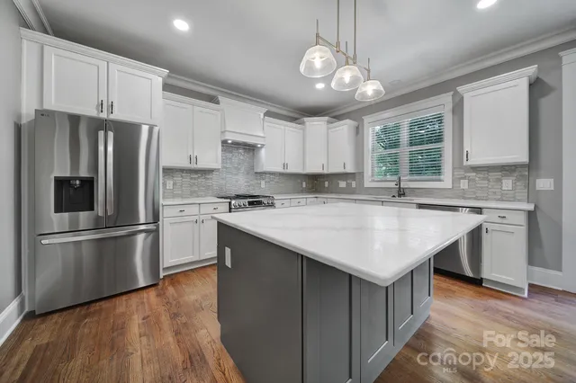 a kitchen with a stove and wooden floor