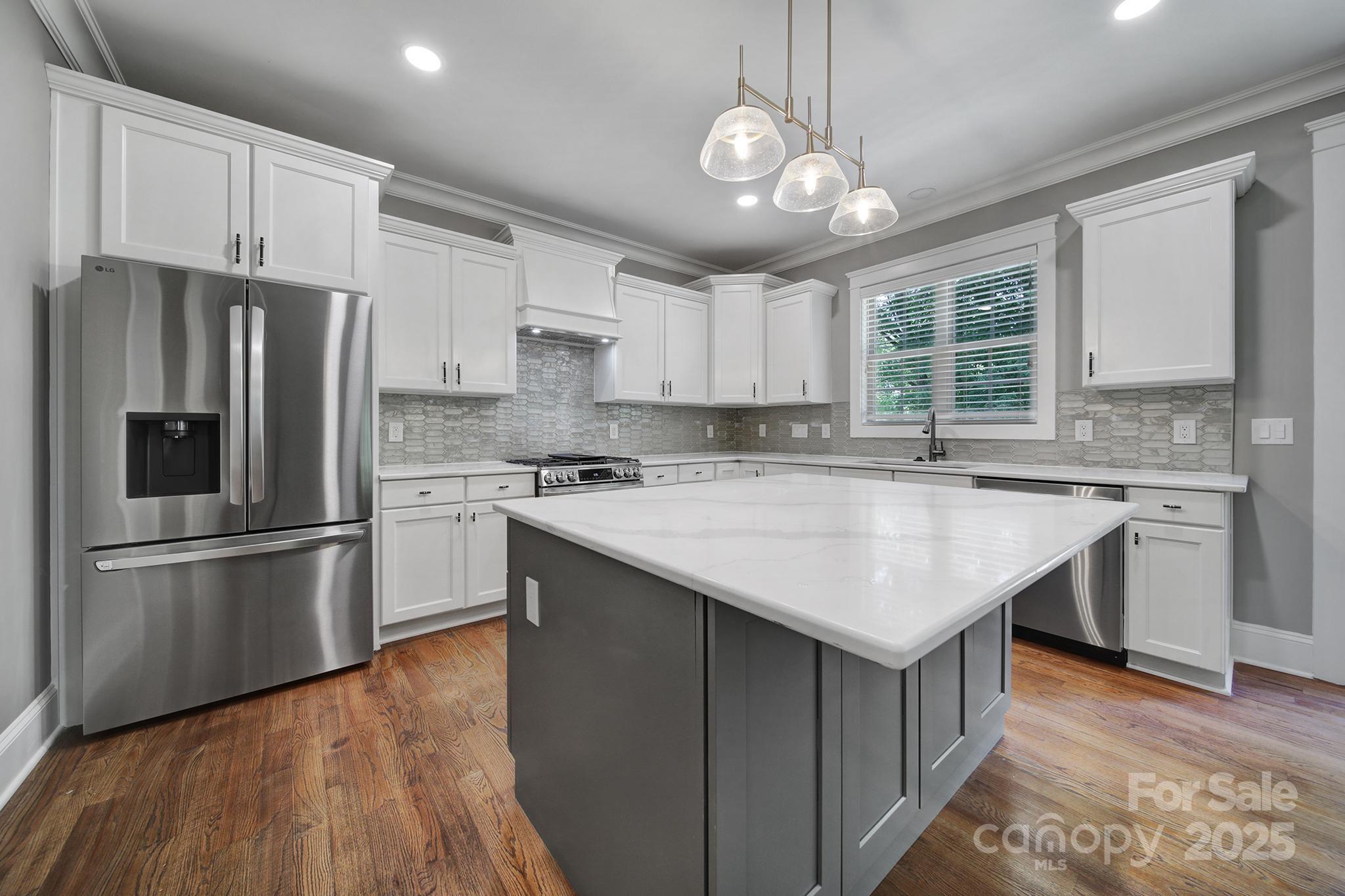 5633 Open Book Lane Charlotte, NC 28270 - Photo 16 of 48 a kitchen with kitchen island granite countertop a sink appliances cabinets and counter space