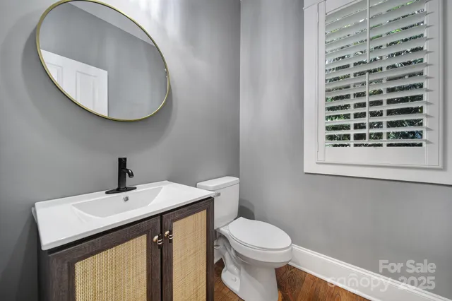 a view of an empty room with wooden floor fireplace and a window