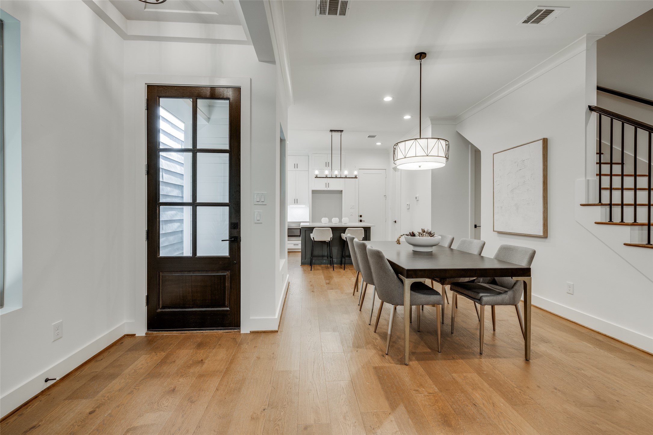 2325 Richton Street Houston, TX 77098 - Photo 8 of 47 a dining room with wooden floor a chandelier a wooden table and chairs