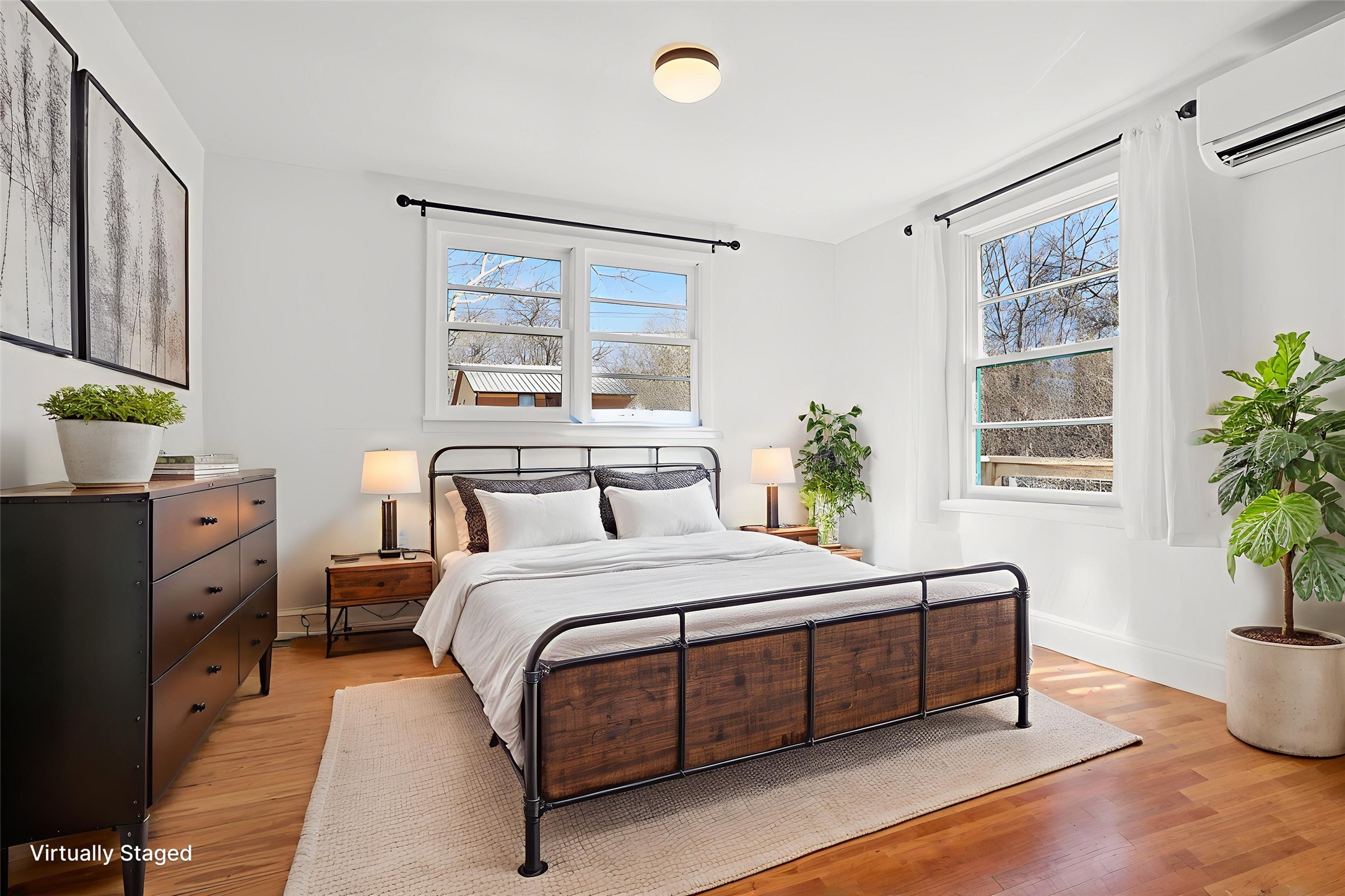 5603 Harold Court Austin, TX 78721 - Photo 11 of 31 a bedroom with a bed and a potted plant on the dresser