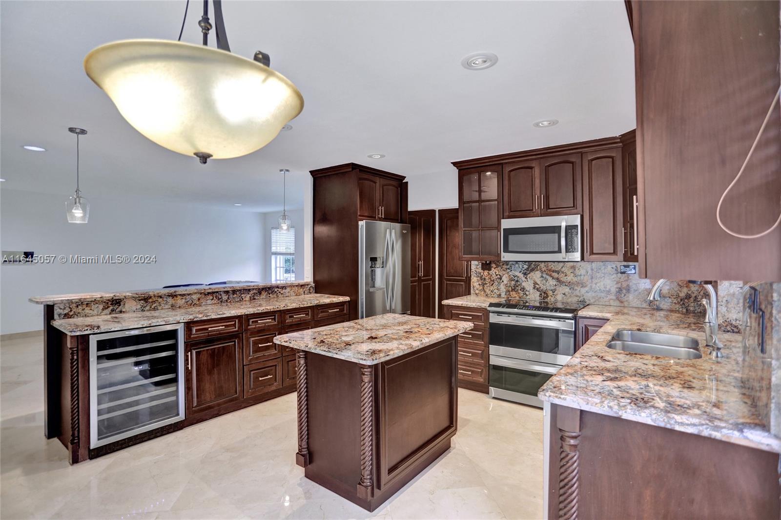 15591 Southwest 42nd Lane Miami, FL 33185 - Photo 12 of 60 a kitchen with stainless steel appliances granite countertop a stove a sink dishwasher and a refrigerator with wooden cabinets