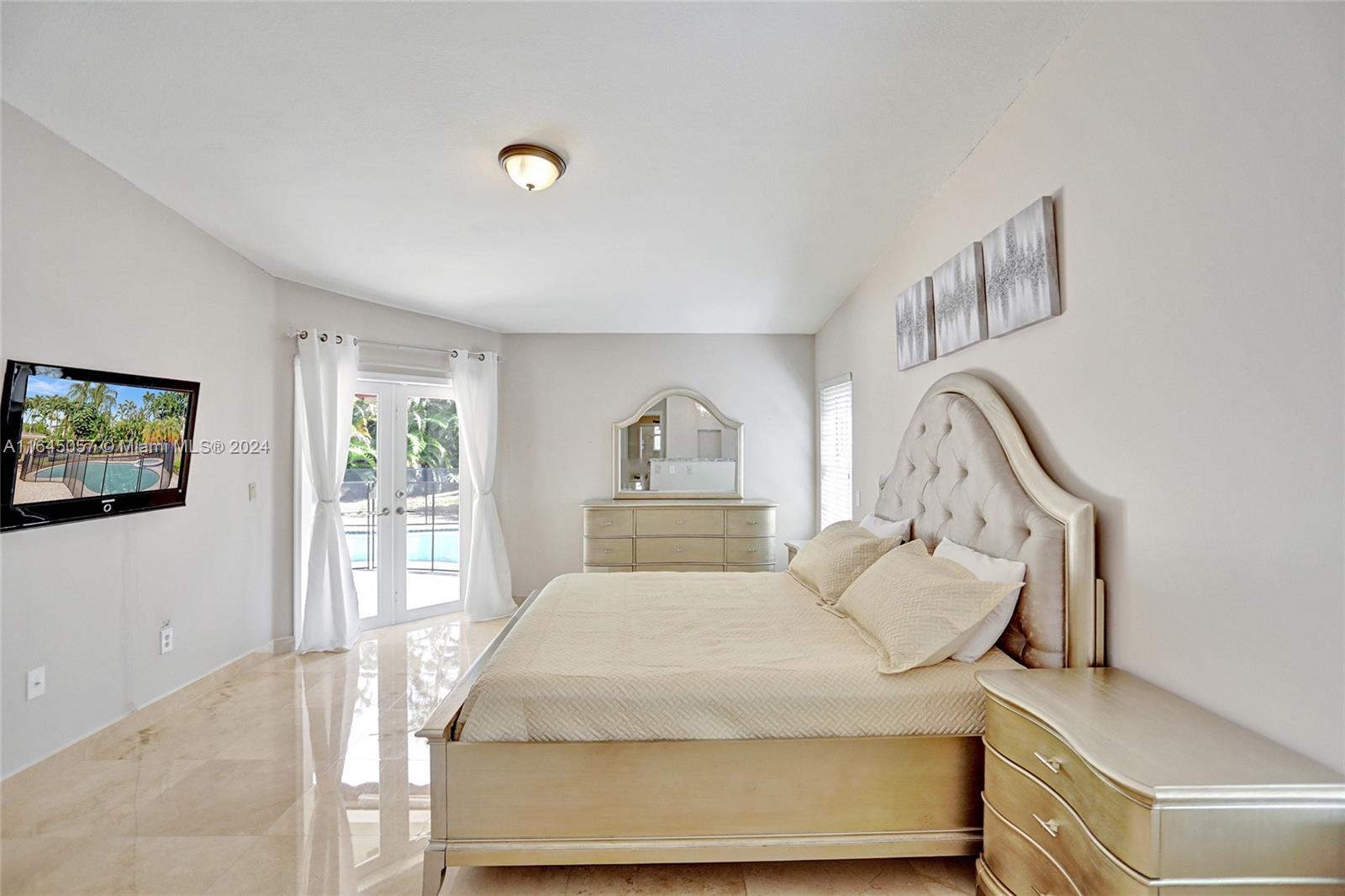 15591 Southwest 42nd Lane Miami, FL 33185 - Photo 15 of 60 a bedroom with a large bed and a window