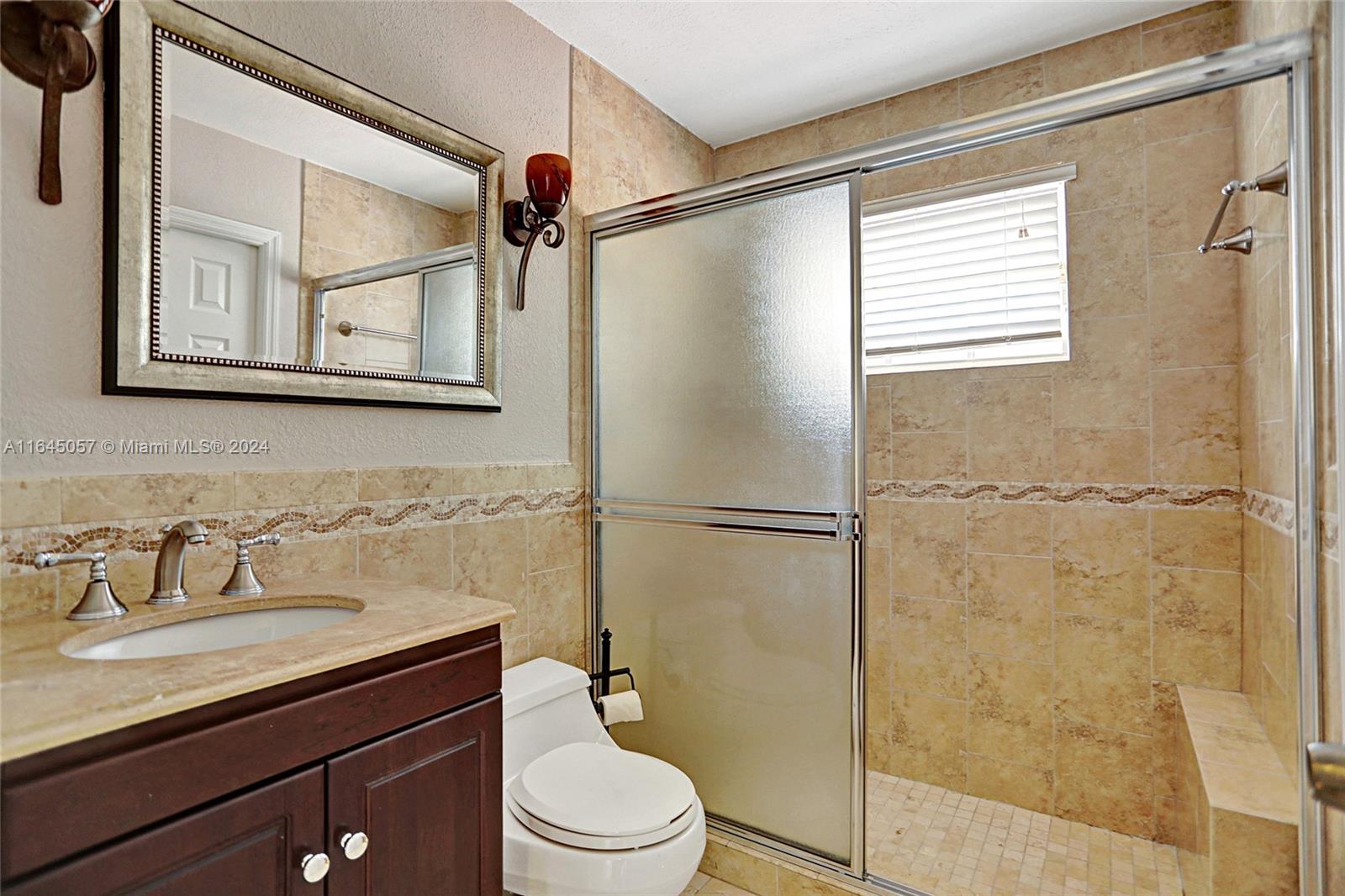 15591 Southwest 42nd Lane Miami, FL 33185 - Photo 39 of 60 a bathroom with a shower sink vanity mirror and toilet