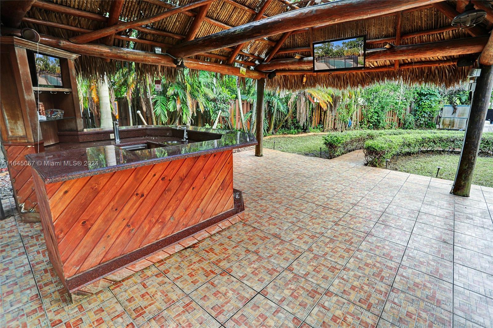 15591 Southwest 42nd Lane Miami, FL 33185 - Photo 48 of 60 a view of a patio with a table and chairs under an umbrella