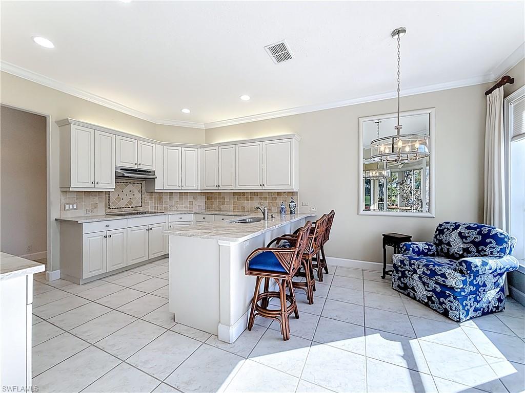 3051 Lancaster Drive, Unit 2 Naples, FL 34105 - Photo 19 of 43 a kitchen with cabinets and chairs