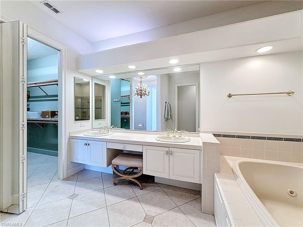3051 Lancaster Drive, Unit 2 Naples, FL 34105 - Photo 25 of 43 a bathroom with a bathtub sink and mirror