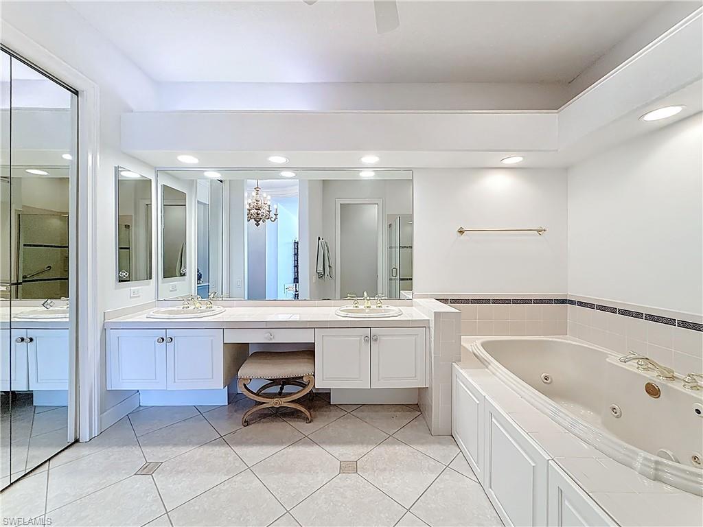 3051 Lancaster Drive, Unit 2 Naples, FL 34105 - Photo 27 of 43 a bathroom with a bathtub sink and mirror