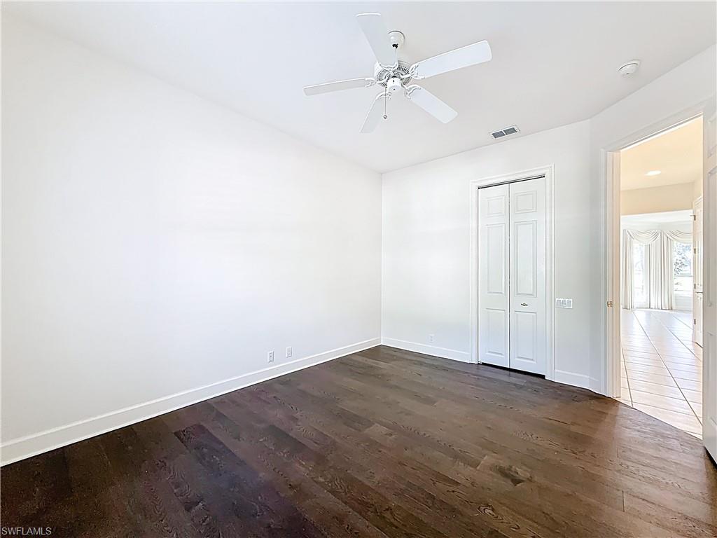 3051 Lancaster Drive, Unit 2 Naples, FL 34105 - Photo 29 of 43 an empty room with wooden floor and ceiling fan