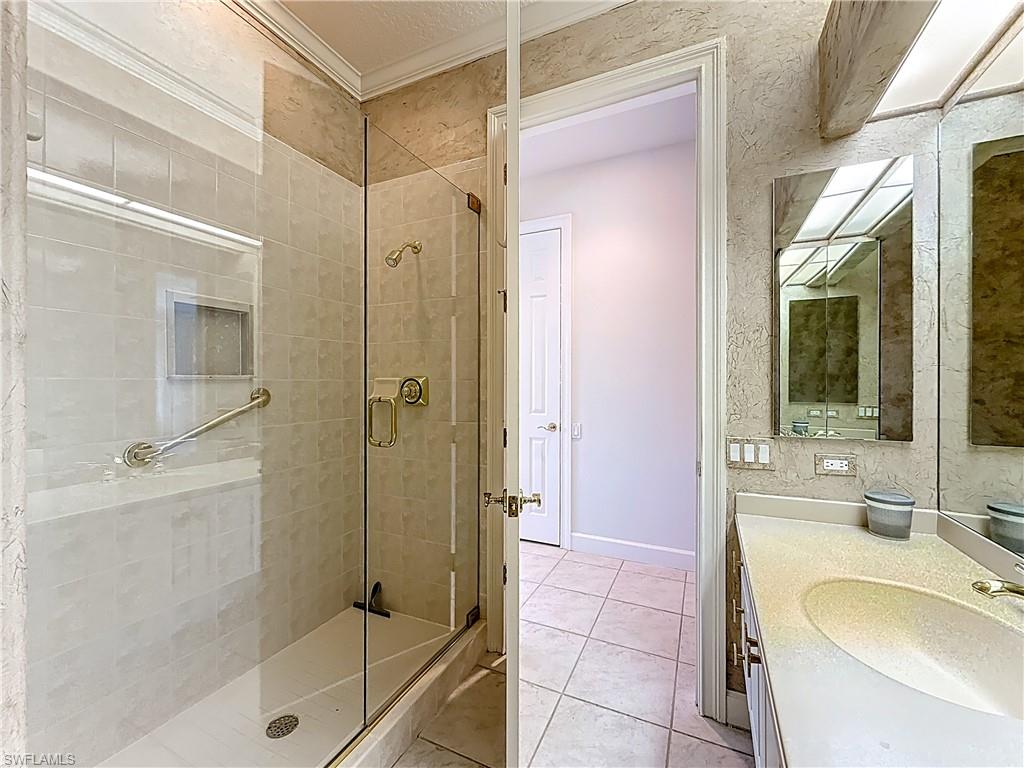 3051 Lancaster Drive, Unit 2 Naples, FL 34105 - Photo 30 of 43 a bathroom with a shower sink and mirror