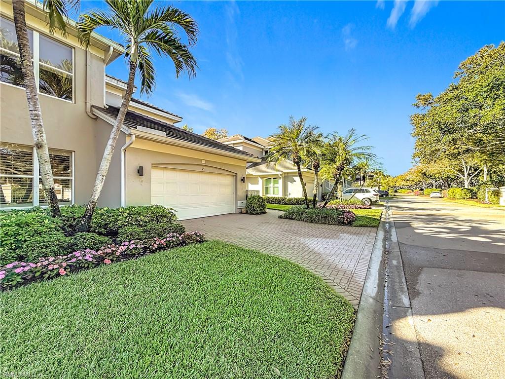 3051 Lancaster Drive, Unit 2 Naples, FL 34105 - Photo 4 of 43 a front view of a house with a yard and garage