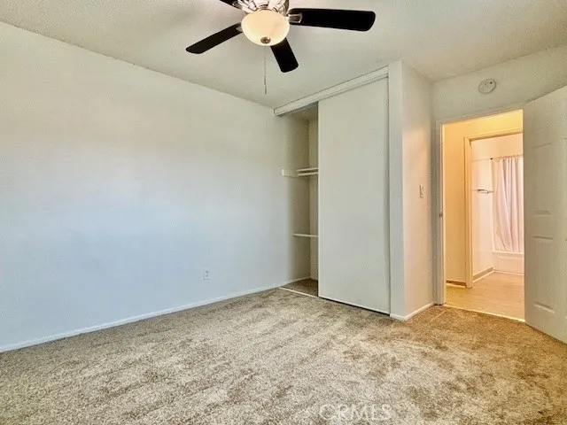 an empty room with a ceiling fan and a window