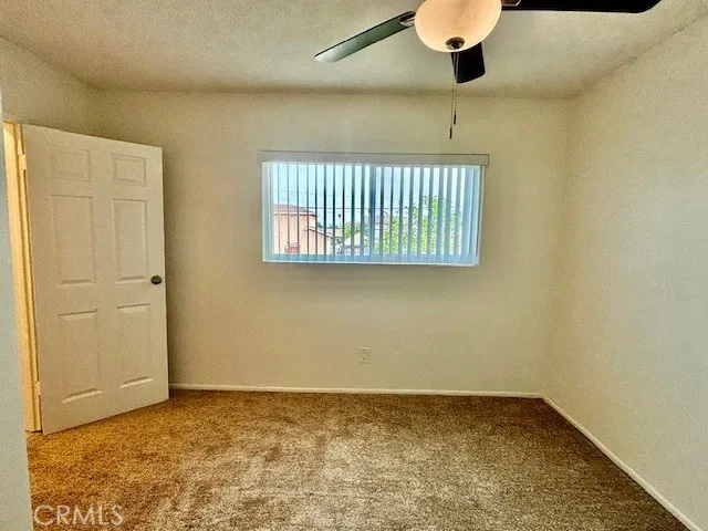 an empty room with a ceiling fan and a window