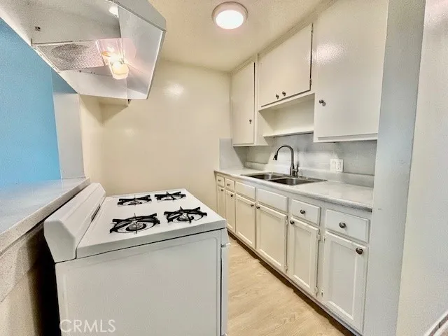a kitchen with granite countertop a sink stainless steel appliances and cabinets