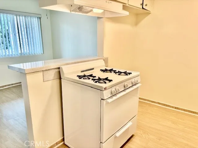 a white kitchen with sink a stove and a refrigerator