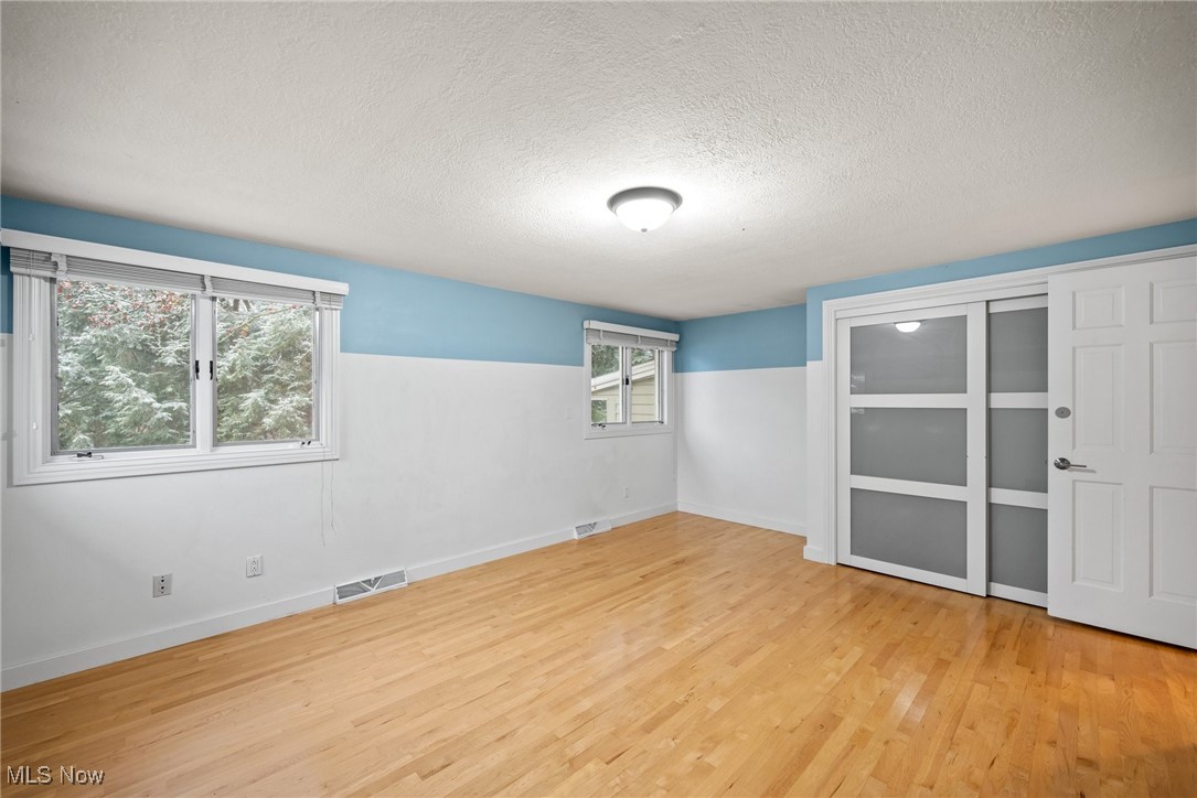2711 Glenmont Road Northwest Canton, OH 44708 - Photo 38 of 42 Empty room with wood finished floors and a textured ceiling