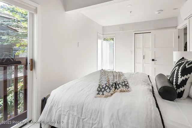 a bedroom with a bed a mirror and a window