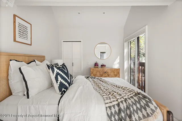 a bedroom with a large bed and wooden floor