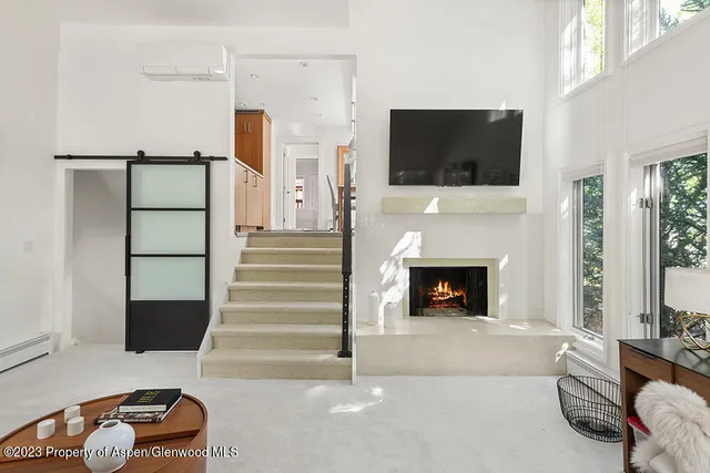 a living room with furniture a flat screen tv and a fireplace