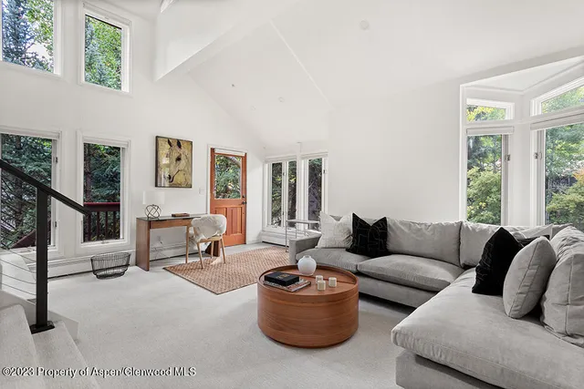 a living room with furniture a rug and a large window