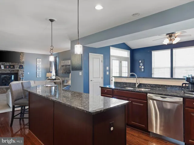a kitchen with granite countertop a sink a counter top space appliances and cabinets