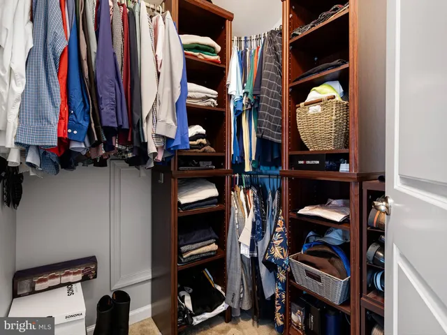 a view of walk in closet with clothes and shoes