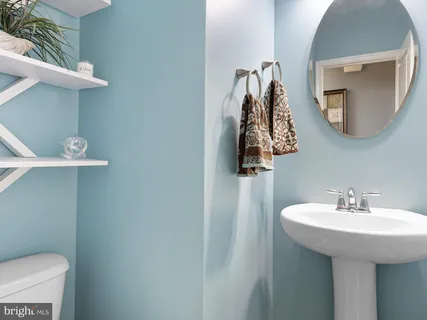 a bathroom with a sink a toilet and mirror