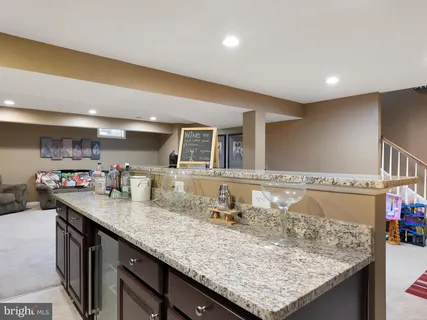 a bathroom with a granite countertop sink and a large mirror