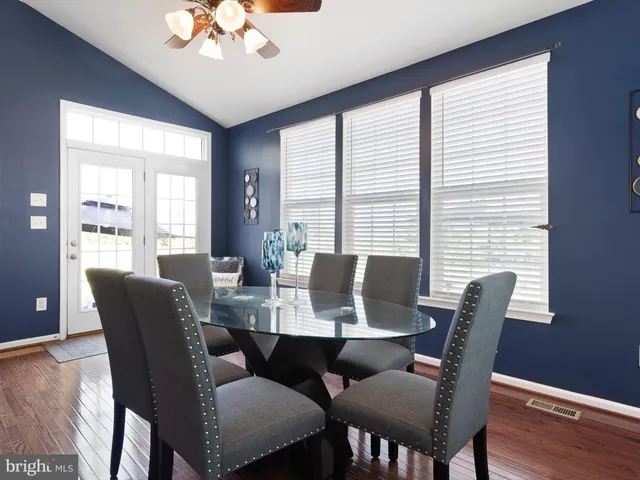 a dining room with furniture a chandelier and wooden floor