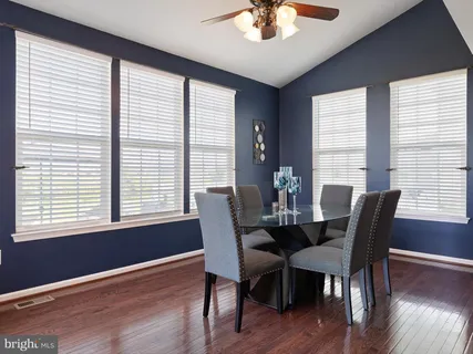 a view of a dining room with furniture windows and wooden floor