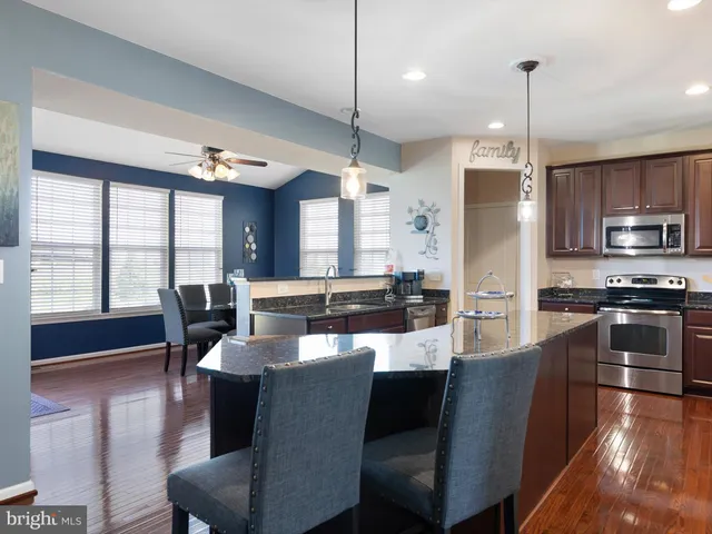 a large kitchen with a table chairs refrigerator and microwave