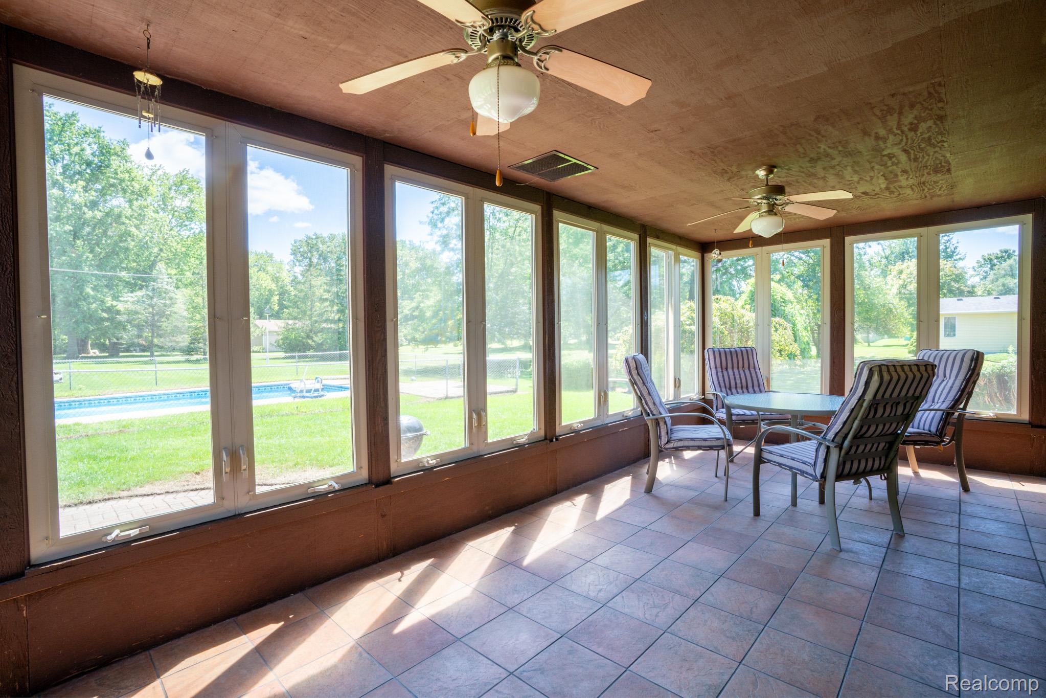 12900 Maxwell Road Carleton, MI 48117 - Photo 42 of 59 Screened room featuring full-height windows, tiled flooring, and dual ceiling fans